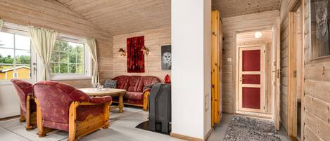 A log cabin interior with a dining area, a sofa, and a fireplace.