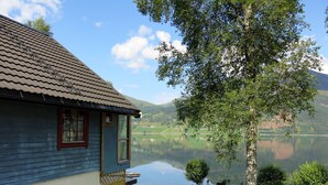 Ein Haus mit Blick auf einen See und Berge.