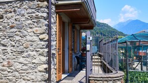 A stone building with a wooden door and a metal gate.