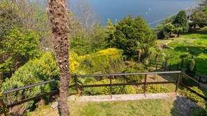 Une vue panoramique d’un paysage montagneux, avec un lac et une rambarde en bois au premier plan.