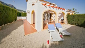 A villa with a patio area featuring two sun loungers, a table, and chairs. - Residencial Puerta de Calpe by Interhome (Calpe/Calp)