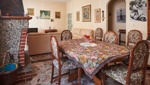 A dining area with a table set for six, surrounded by floral-patterned chairs.