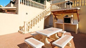 A patio with ornate tables and a staircase leading to a balcony. - Altamar by Interhome (Calpe/Calp)