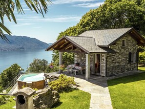 A stone house with a pool, surrounded by lush greenery and a view of a lake. - Lo Scoiattolo by Interhome (Cannero Riviera)