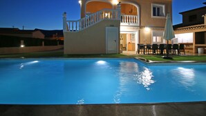 Una casa a due piani con piscina, un balcone e un patio.