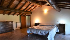 Une chambre à coucher avec un plafond en bois, un lit, une commode et une table de chevet.