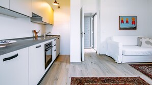 A modern kitchen with white cabinets, a grey countertop, and a hanging light fixture. - Villetta ai Pini by Interhome (Lago di Caldonazzo)