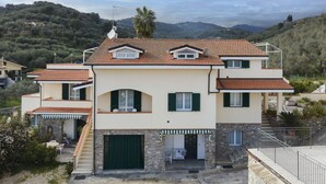 Ein zweistöckiges Haus mit Ziegeldach, Steinaußenwand und grüner Tür.