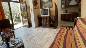 Una sala de estar con televisor, sofá, comedor y cocina.