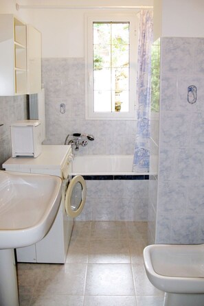 A bathroom with a bathtub, a toilet, and a sink.