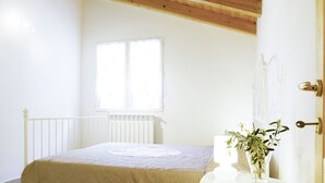 A bedroom with a bed, a window, a radiator, and a door. - Marco (PRE172) by Interhome (Molini di Prelà)