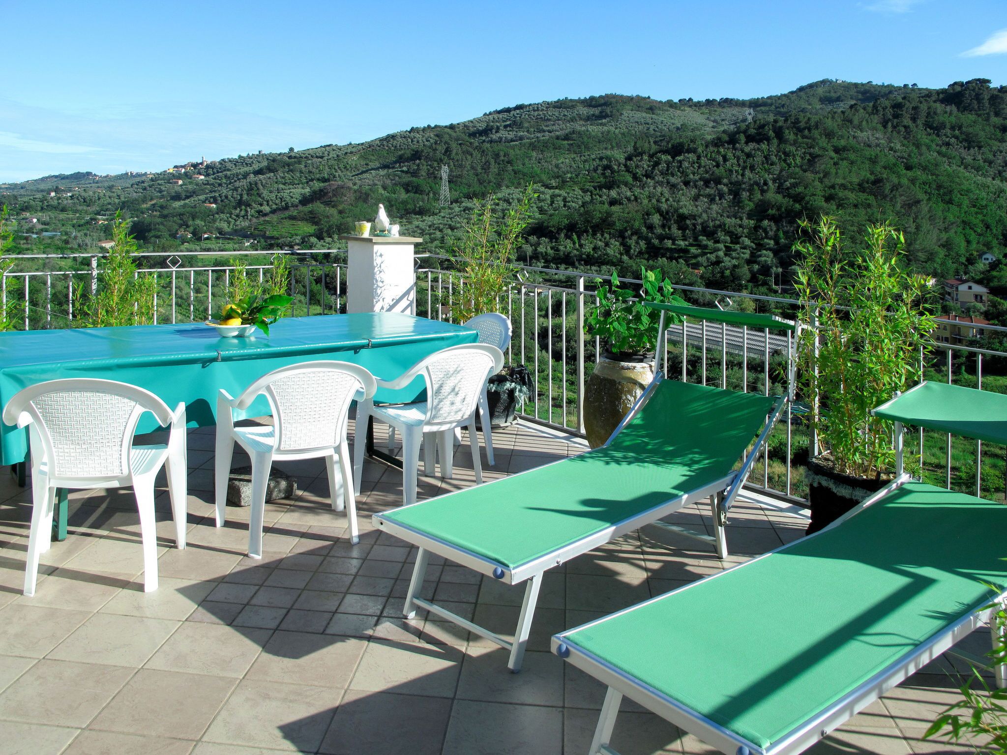 Un espace piscine comprenant une table et des chaises, un billard vert et des chaises longues.