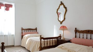 Ein Schlafzimmer mit zwei Betten, einem Spiegel und einer Lampe.