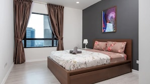 Une chambre moderne avec un grand lit, une vue sur la ville et une peinture abstraite aux couleurs vives accrochée au mur.