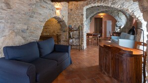 A rustic stone interior with a wooden bar and a sofa. - U Figu du Camin by Interhome (Pontedassio)