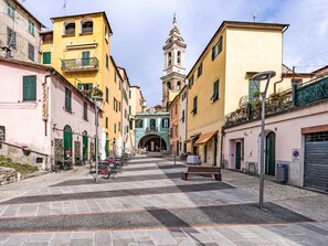 A historic street with buildings, a central archway, and a bell tower. - Apartment Sorei by Interhome (Dolcedo)