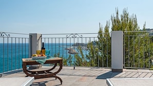 A balcony with a view of the sea, a table with fruits and a bottle, and a metal railing. - Orange (SLR353) by Interhome (San Lorenzo al Mare)