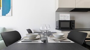 A dining table set with bowls, glasses, and chopsticks, with a microwave and menu in the background. - Italianway Comfort - D'aragona 2 (Milan)
