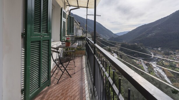Un balcon donnant sur une vallée et des montagnes.
