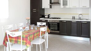 A modern kitchen with dark cabinets, a gas stove, and a built-in oven. - Arco (SLR350) by Interhome (San Lorenzo al Mare)