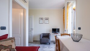Ein gemütlicher Wohnbereich mit Essplatz, Fernseher und kleinem Tisch.