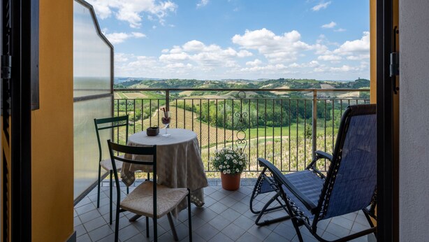 Ein Balkon mit Tisch, Stühlen und einer Blumentopf.