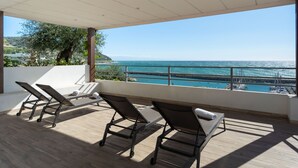 Ein Balkon mit zwei Liegestühlen und Blick aufs Meer.