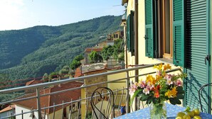 Un balcon avec une table, des fleurs et des citronniers.