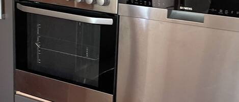 A kitchen with a built-in oven and a stainless steel dishwasher.