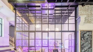 A modern interior with a glass partition, a staircase, and a chalkboard with festive greetings. - Xiaochengshanyue Inn ((Dali Ancient City South Gate) (Dali City)