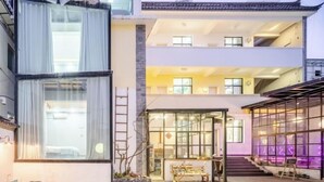 A modern building with a ground floor open space, a second floor with balconies, and a third floor with large windows. - Xiaochengshanyue Inn ((Dali Ancient City South Gate) (Dali City)