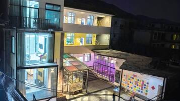 A multi-level building with glass balconies and a visible interior.