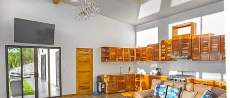 Un vaste espace de vie comprenant un grand canapé, des meubles en bois et un lustre.