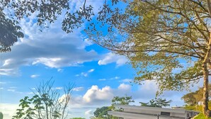 A modern house with a dirt driveway and a stone wall. - Casa Toucan (Bahía Ballena)