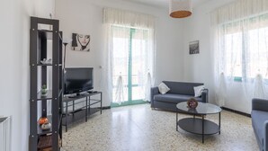 Ein modernes Wohnzimmer mit Fernseher, Sofa, Couchtisch und Dekorationselementen.