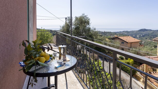 Ein Balkon mit einem für zwei Personen gedecktem Tisch, mit Blick auf eine reizvolle Landschaft.
