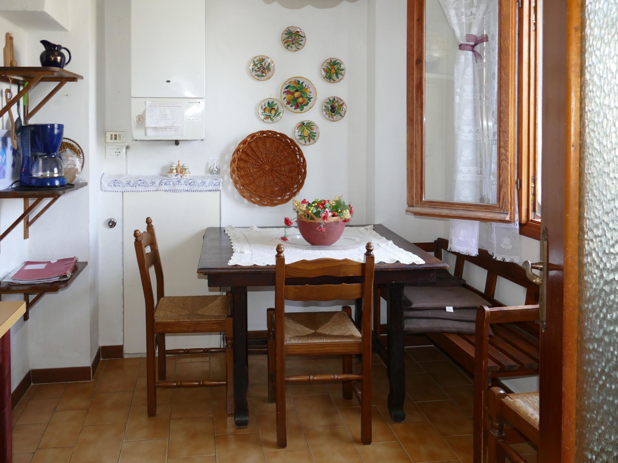 Un coin repas avec une table en bois, quatre chaises, un panier en osier et une plante en pot.