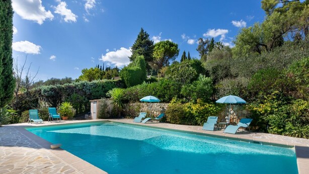 A swimming pool with clear blue water, surrounded by stone tiles and greenery. - La Garance by Interhome (Grasse)