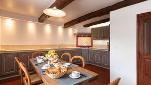 A dining area with a wooden table set for breakfast, including bread, fruit, and eggs. - La Bastide Haute by Interhome (La Garde Freinet)