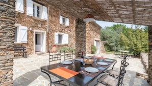 A stone building with a covered outdoor dining area. - La Bastide Haute by Interhome (La Garde Freinet)