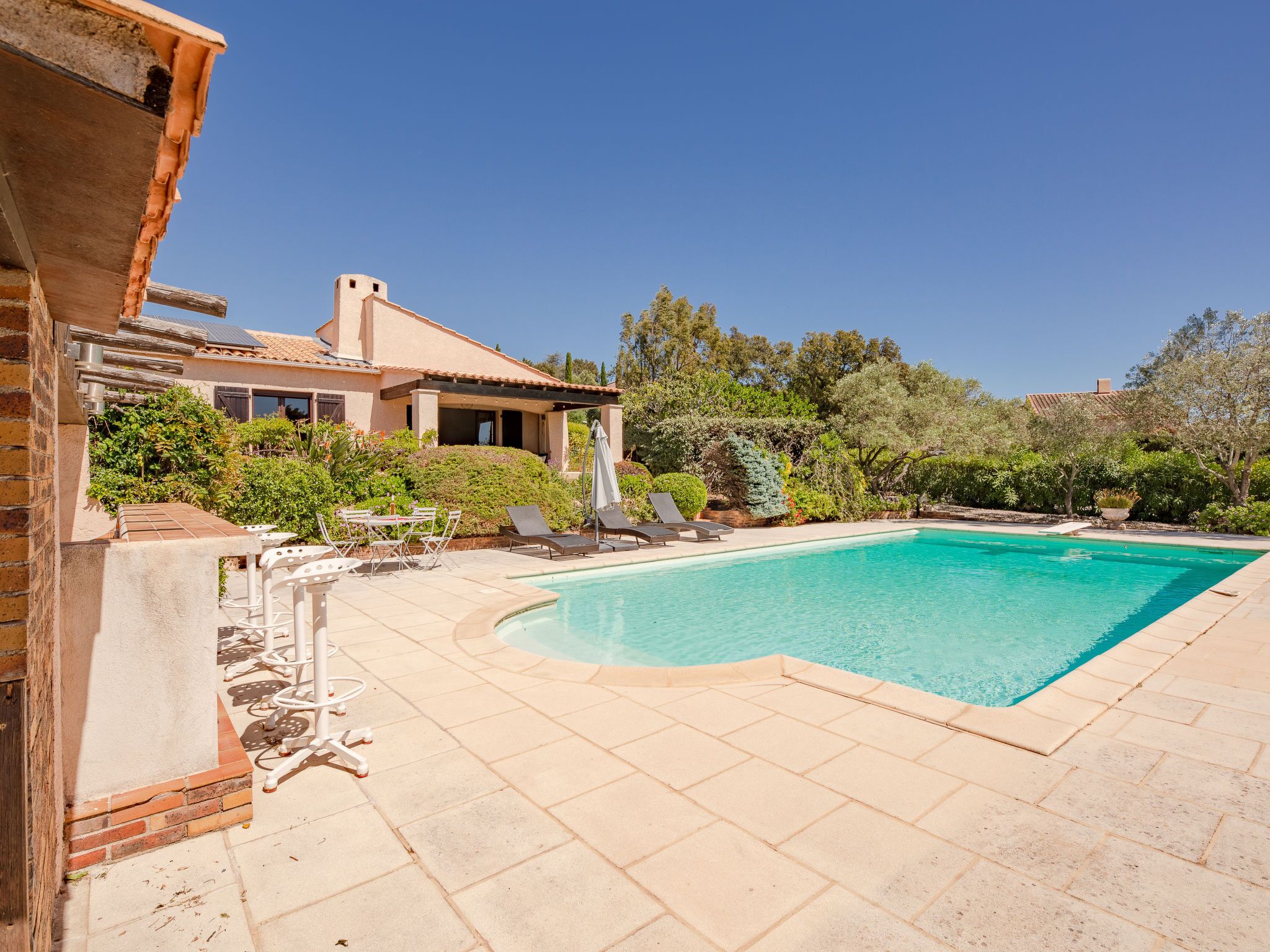 A swimming pool with lounge chairs and a patio area.