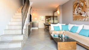 Ein modernes Wohnzimmer mit einer Couch, einem Couchtisch und einer Treppe.