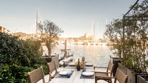 Ein Essbereich im Freien mit Blick auf einen Hafen und Boote.