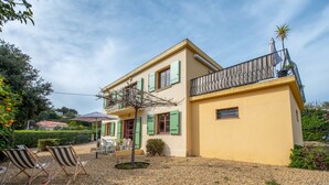 A two-story house with a balcony, a gravel driveway, and outdoor seating. - Villa Marenco by Interhome (La Croix-Valmer)