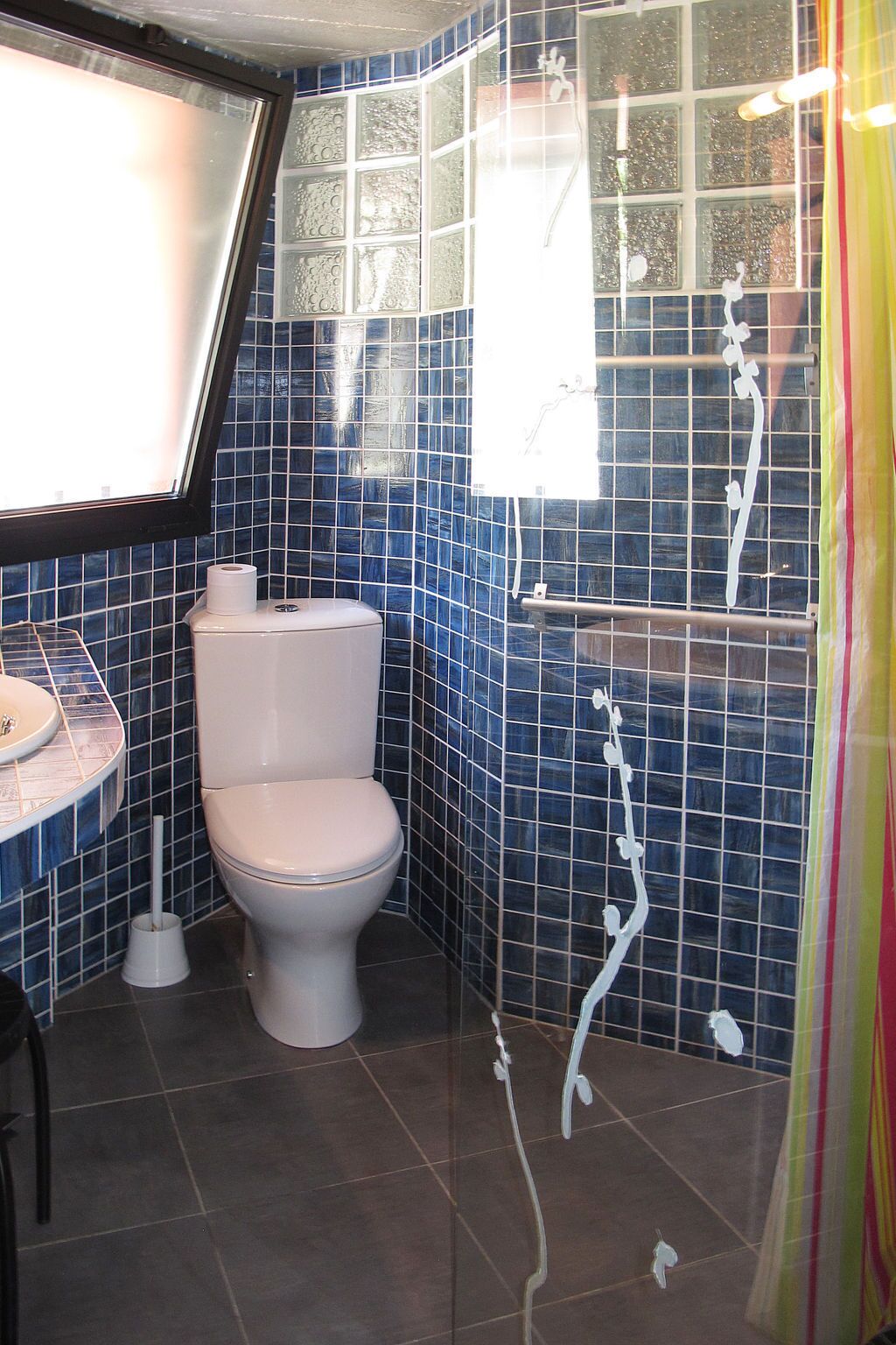Ein Badezimmer mit Toilette, Waschbecken und Duschbereich.