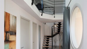 A modern interior with a staircase, a door, and a window.
