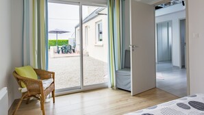 A room with a sliding glass door leading to an outdoor patio with a table and chairs.