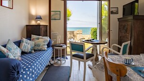 Una habitación con cama, mesa, sillas y vista al mar.