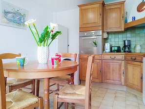 A kitchen with wooden cabinets, a stainless steel oven, and a coffee maker.