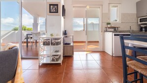 A modern kitchen with a dishwasher, a coffee machine, and a small dining area with a table and chairs.